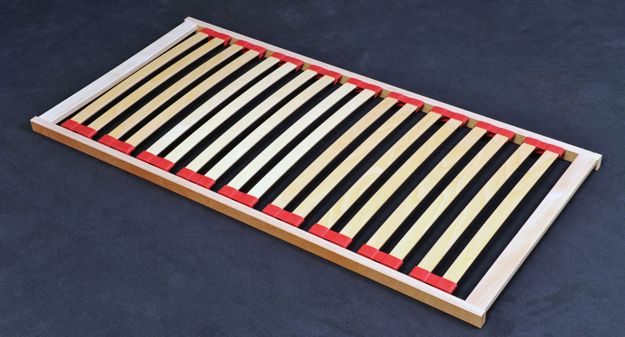 Lattenrost aus Holz mit roten Kappen, stabil und flexibel, ideal für Matratzen.