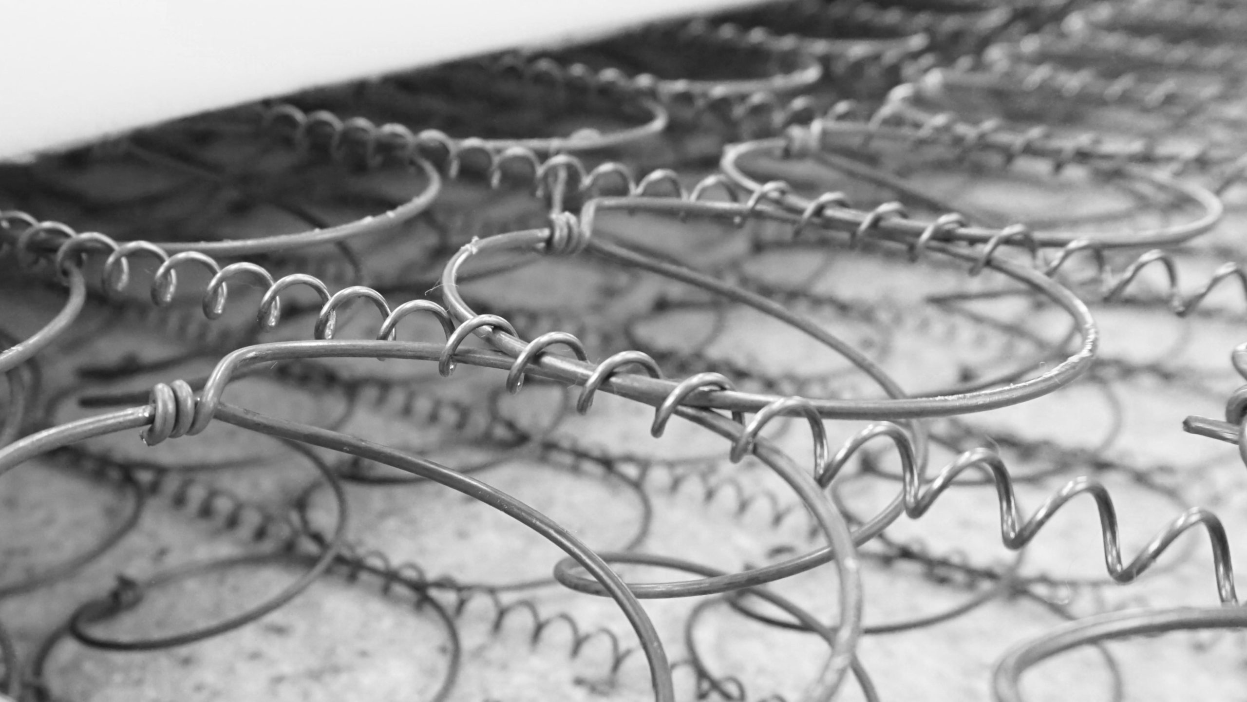 Nahaufnahme von Metallfedern einer Matratze, die spiralförmig angeordnet sind.