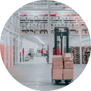 Ein Gabelstapler transportiert Kartons in einem modernen Lager mit hohen Regalen.