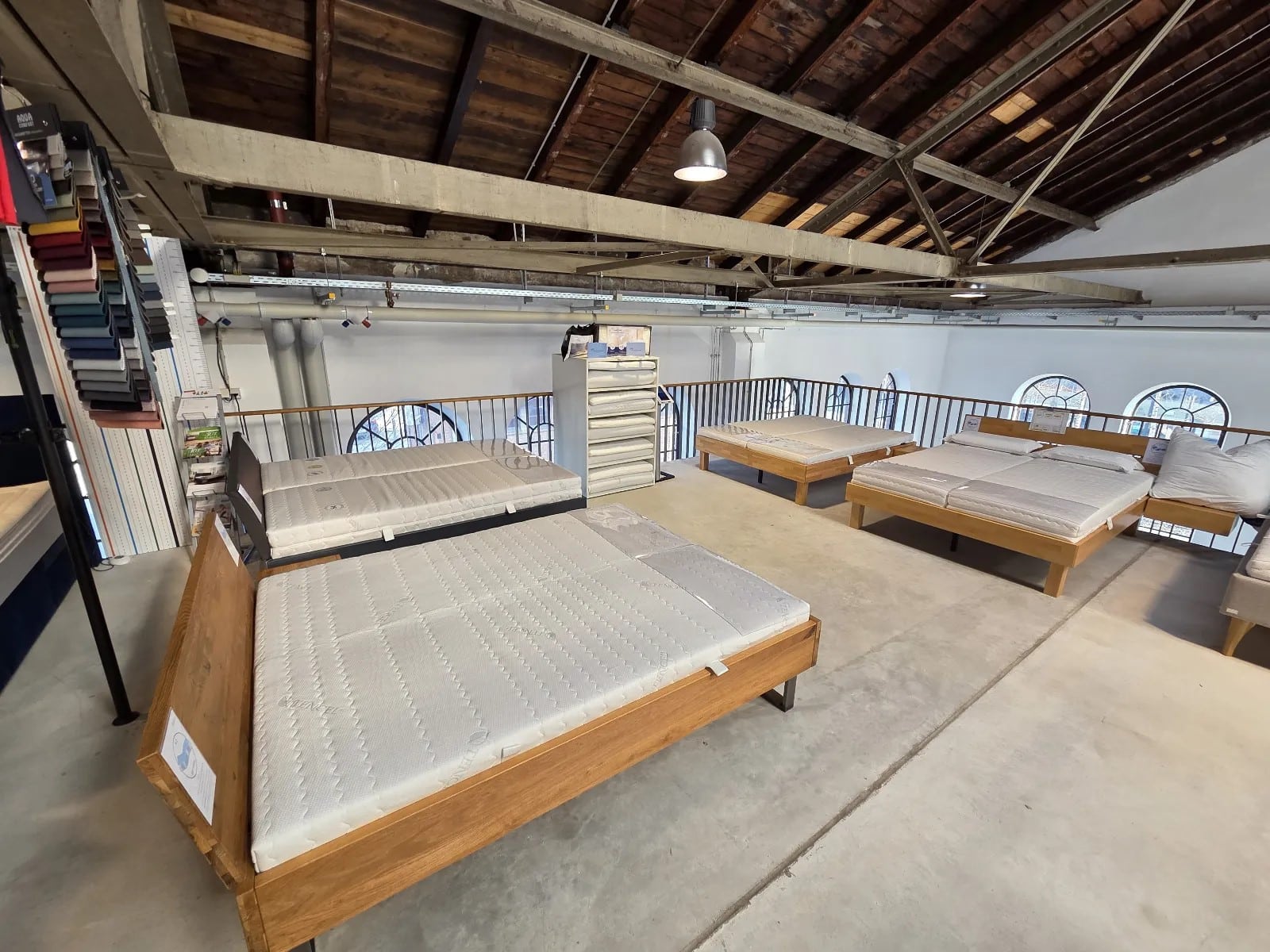 Showroom von AM Qualitätsmatratzen in München mit mehreren Holzbetten und Matratzen in einem modernen, hellen Raum.
