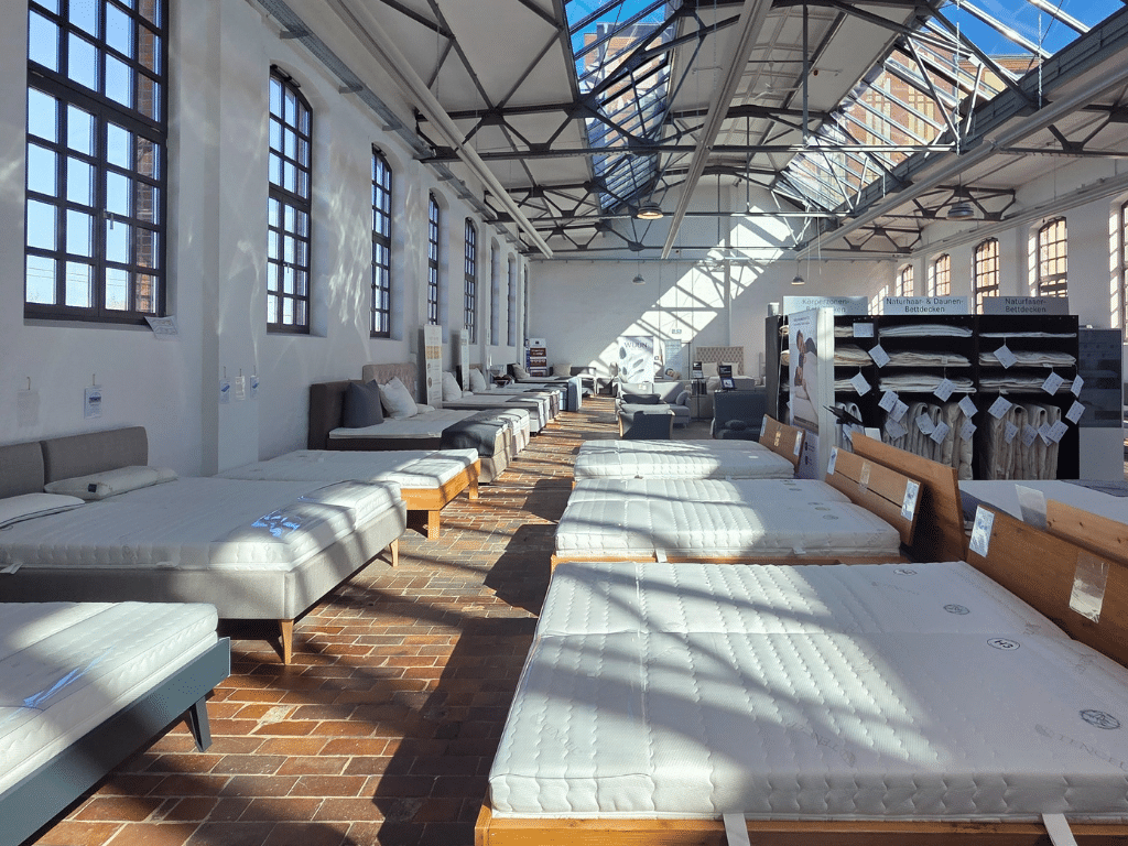 AM Qualitätsmatratzen Showroom in Berlin, einige Betten sind zu sehen auf denen Matratzen liegen, sonniger Lichteinfall