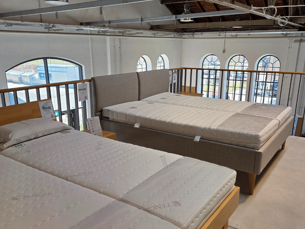 Showroom von AM Qualitätsmatratzen in München andere Seite mit zwei weiteren Betten auf einer Empore