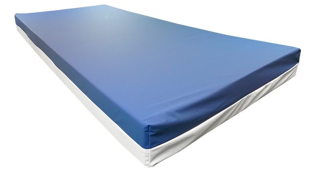 Matratze mit blauer Oberseite und weißem Bezug, geeignet für Pflege- und Komfortbedarf.
