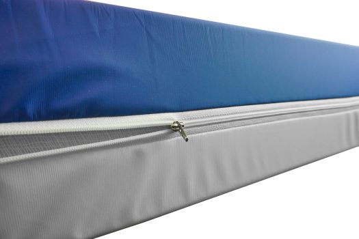 Matratze mit blauer Oberseite und grauem Reißverschlussbezug, ideal für Pflegezwecke.