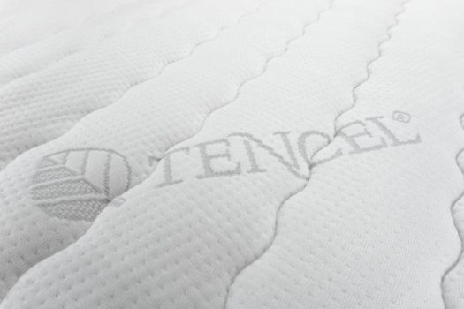 Weißer Stoff mit eingeprägtem TENCEL®-Schriftzug und strukturiertem Muster.