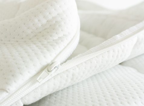 Detailaufnahme eines weißen Matratzenbezugs aus Tencel mit Reißverschluss und strukturierter Oberfläche.